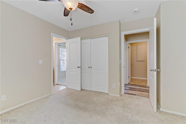 unfurnished bedroom featuring carpet floors, ceiling fan, baseboards, and a closet