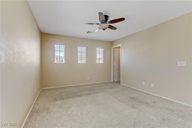 unfurnished room featuring a ceiling fan, light colored carpet, visible vents, and baseboards