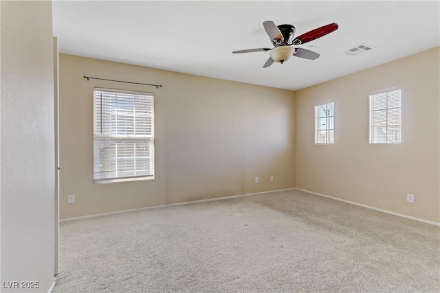 carpeted empty room featuring visible vents, ceiling fan, and baseboards