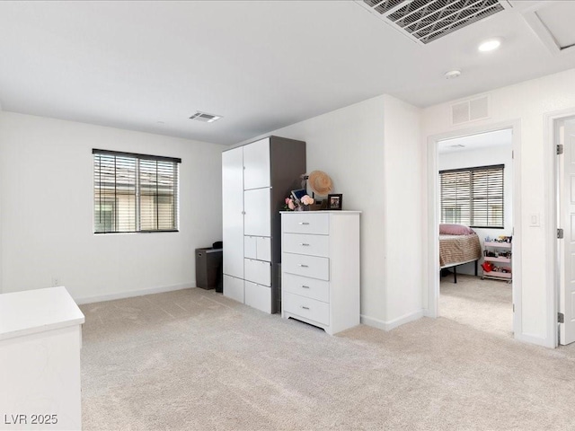 unfurnished bedroom with baseboards, visible vents, and light colored carpet