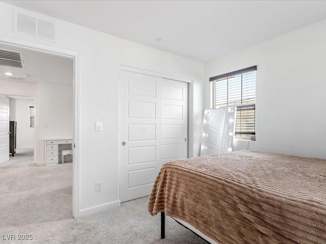 bedroom with light carpet, baseboards, visible vents, and a closet