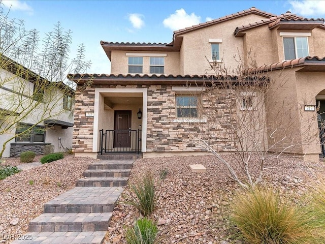 view of front facade with stone siding, a tile roof, and stucco siding