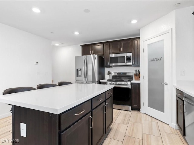 kitchen featuring a kitchen island, appliances with stainless steel finishes, light countertops, and recessed lighting