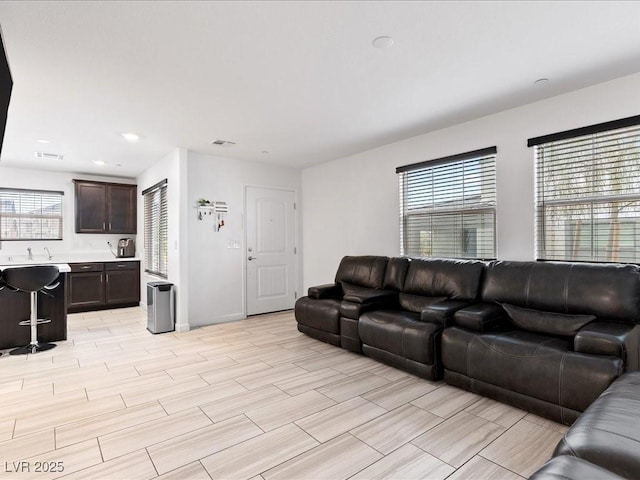 living room featuring recessed lighting, wood tiled floor, visible vents, and baseboards