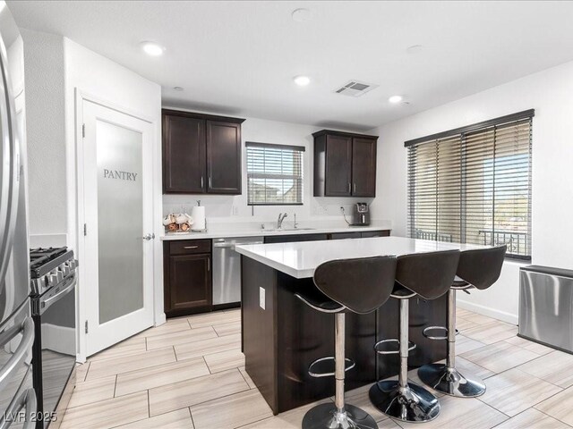 kitchen with visible vents, appliances with stainless steel finishes, light countertops, and dark brown cabinets