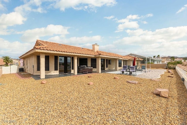 back of property featuring a patio area, a fenced backyard, a chimney, and a tile roof