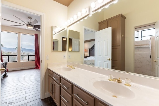 full bathroom featuring ceiling fan, connected bathroom, a sink, and double vanity