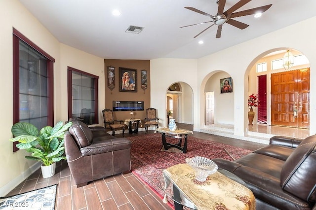 living room featuring arched walkways, ceiling fan, recessed lighting, visible vents, and wood tiled floor