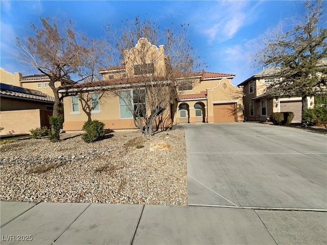 view of front of home featuring stucco siding, concrete driveway, an attached garage, and a tiled roof