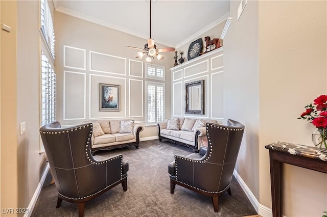 living area with carpet, a high ceiling, ornamental molding, ceiling fan, and baseboards