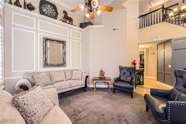 living room featuring carpet, visible vents, ceiling fan, and baseboards