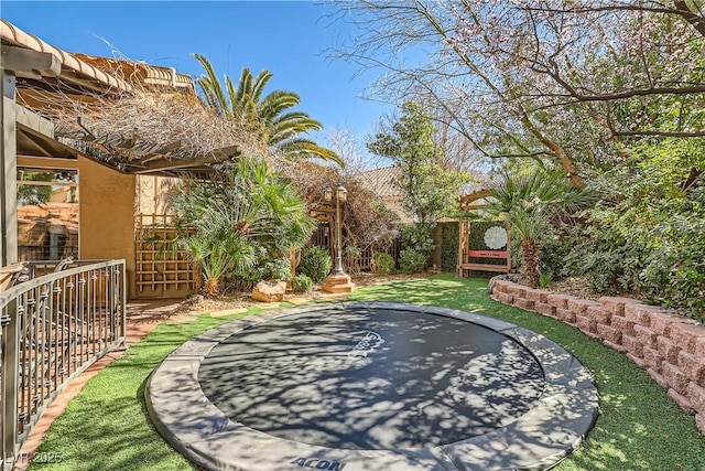 exterior space featuring a trampoline and fence