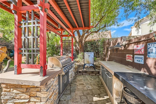 view of patio / terrace featuring area for grilling, an outdoor kitchen, and a fenced backyard