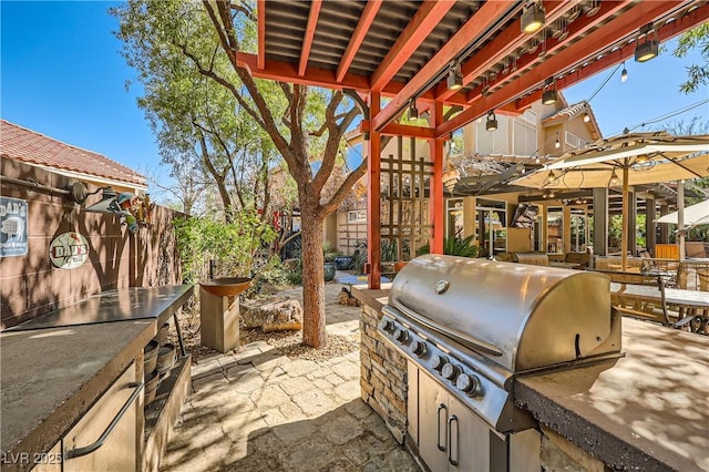 view of patio featuring exterior kitchen and a grill