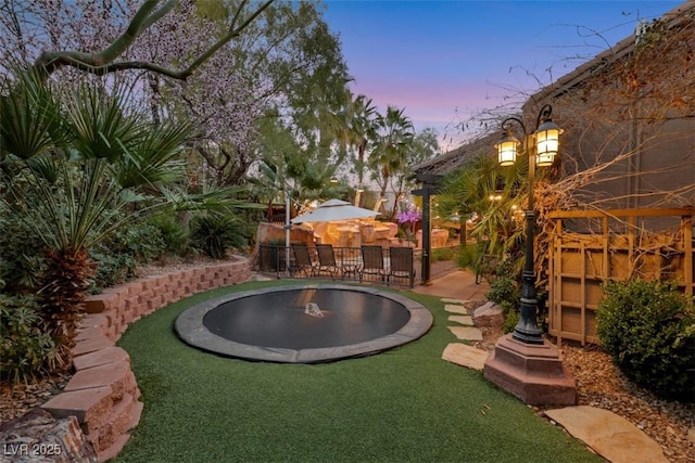 view of yard featuring a trampoline and fence