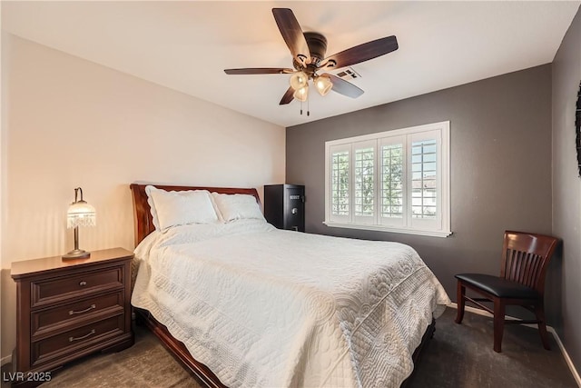 bedroom featuring visible vents, dark carpet, and ceiling fan