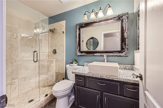 bathroom with toilet, a shower stall, and vanity