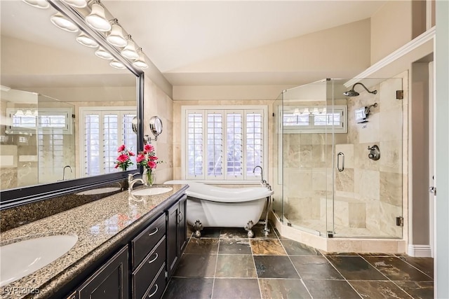 bathroom with vaulted ceiling, a freestanding bath, a sink, and a stall shower