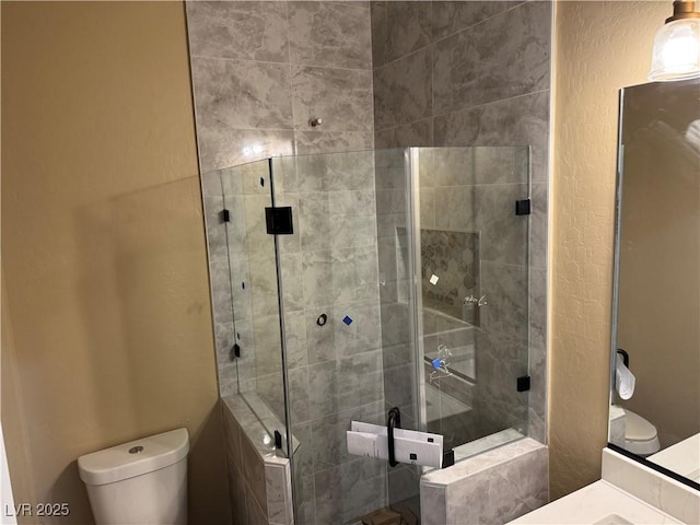 full bathroom with a textured wall, a shower stall, and toilet