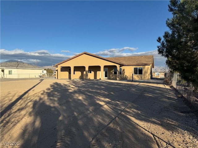 view of front facade with fence and stucco siding