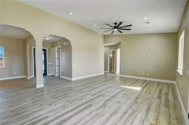 3080 S Prairie Ave, Pahrump, NV 89048 - unfurnished living room featuring arched walkways, a ceiling fan, light wood-style flooring, recessed lighting, and baseboards