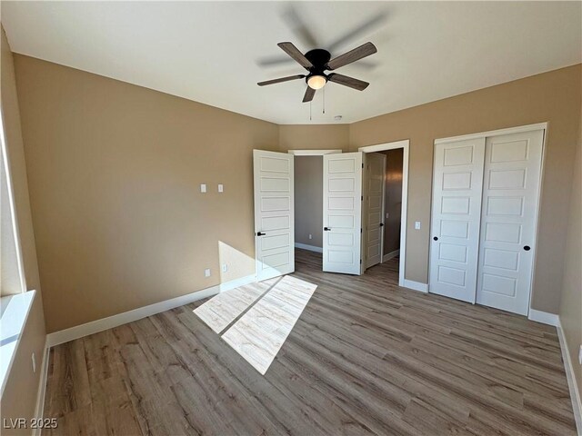 3080 S Prairie Ave, Pahrump, NV 89048 - unfurnished bedroom with baseboards, a closet, and wood finished floors