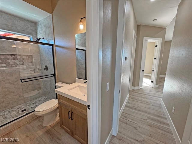3080 S Prairie Ave, Pahrump, NV 89048 - bathroom with toilet, wood finished floors, vanity, a stall shower, and baseboards