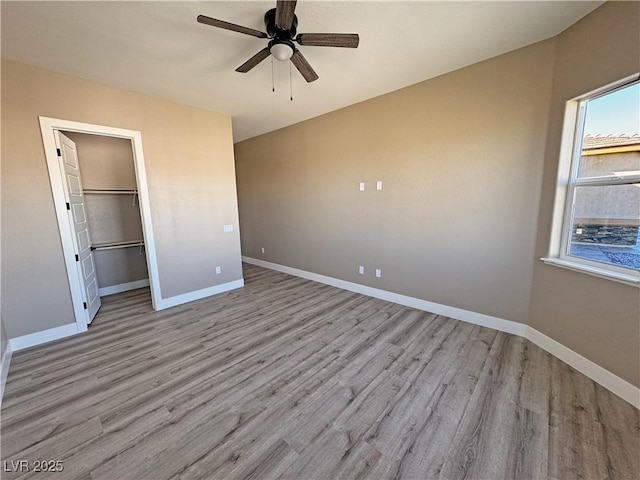 3080 S Prairie Ave, Pahrump, NV 89048 - unfurnished bedroom with a walk in closet, light wood-style flooring, baseboards, and ceiling fan