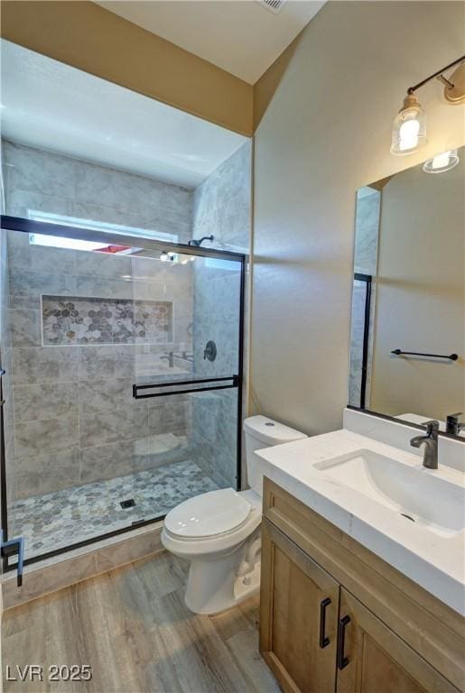 3080 S Prairie Ave, Pahrump, NV 89048 - bathroom featuring a shower stall, vanity, toilet, and wood finished floors