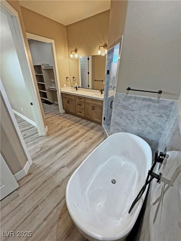 3080 S Prairie Ave, Pahrump, NV 89048 - bathroom with a sink, a shower stall, double vanity, a freestanding tub, and wood finished floors