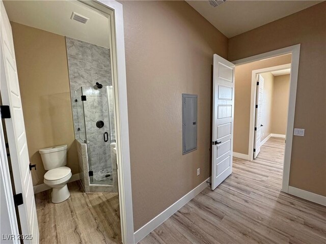 3080 S Prairie Ave, Pahrump, NV 89048 - full bath with a stall shower, toilet, baseboards, visible vents, and wood finished floors