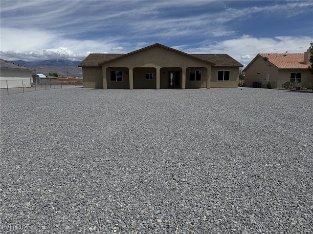 3080 S Prairie Ave, Pahrump, NV 89048 - view of front of house with fence, stucco siding, and a mountain view