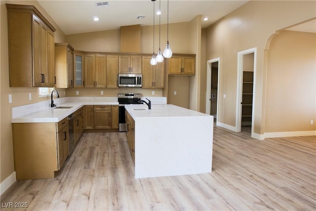 3080 S Prairie Ave, Pahrump, NV 89048 - kitchen with stainless steel appliances, a sink, brown cabinetry, an island with sink, and pendant lighting