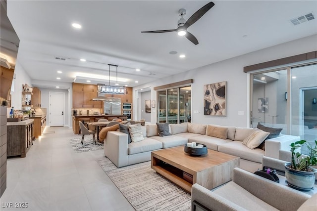 living room with a ceiling fan, recessed lighting, and visible vents