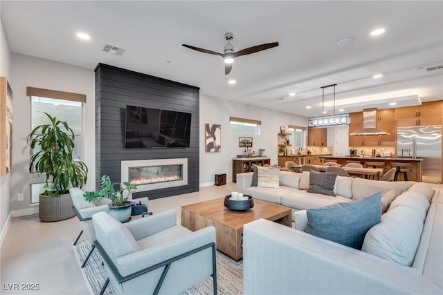 living area featuring baseboards, a fireplace, visible vents, and recessed lighting