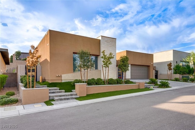 pueblo-style house featuring driveway and stucco siding