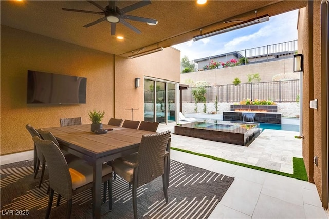 view of patio / terrace featuring an outdoor pool, ceiling fan, an in ground hot tub, fence, and outdoor dining area