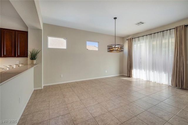 interior space with light tile patterned floors, baseboards, visible vents, and a sink