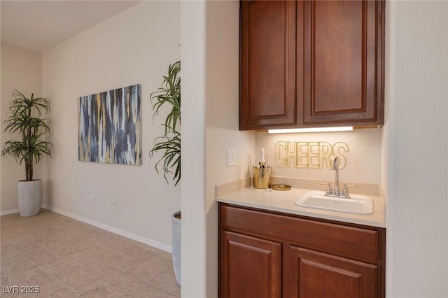 bar with a sink and baseboards