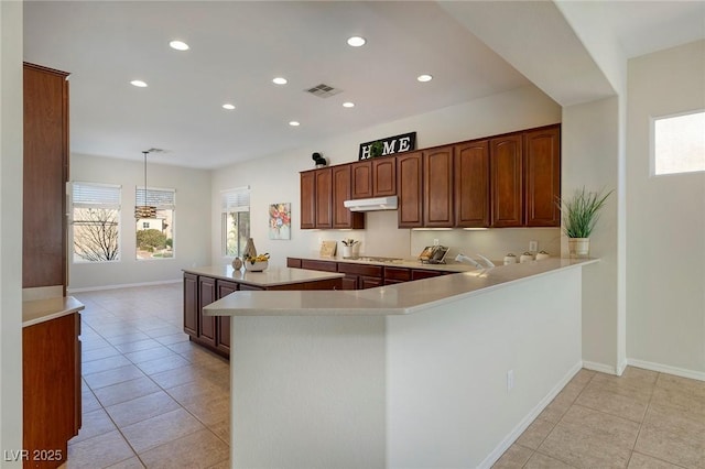 kitchen featuring light countertops, stainless steel gas cooktop, visible vents, and plenty of natural light