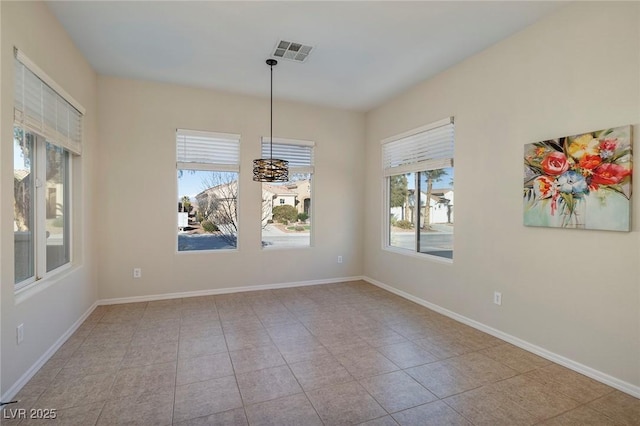 unfurnished dining area featuring baseboards, visible vents, and tile patterned floors