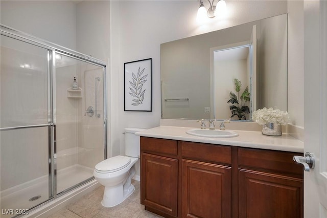 bathroom featuring toilet, a shower stall, vanity, and tile patterned floors