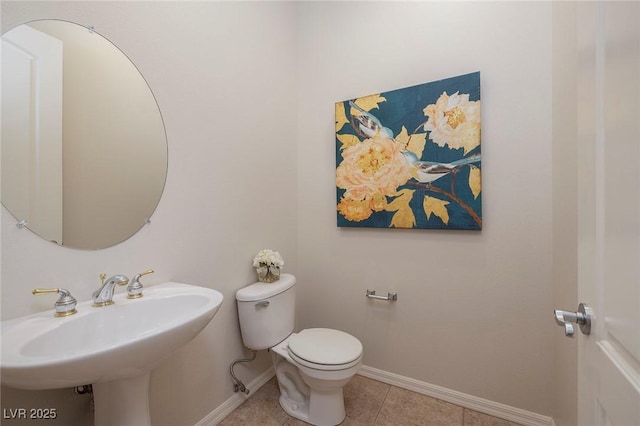 bathroom with a sink, tile patterned floors, toilet, and baseboards