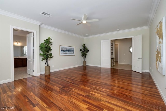 spare room featuring ceiling fan, wood finished floors, visible vents, baseboards, and crown molding