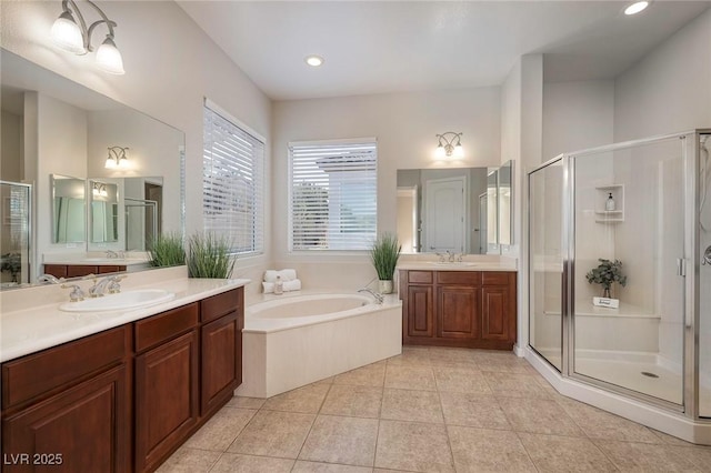 full bath featuring a garden tub, a shower stall, a sink, and tile patterned floors