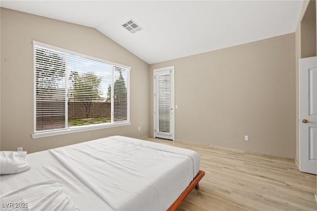 bedroom featuring visible vents, lofted ceiling, and light wood-style flooring