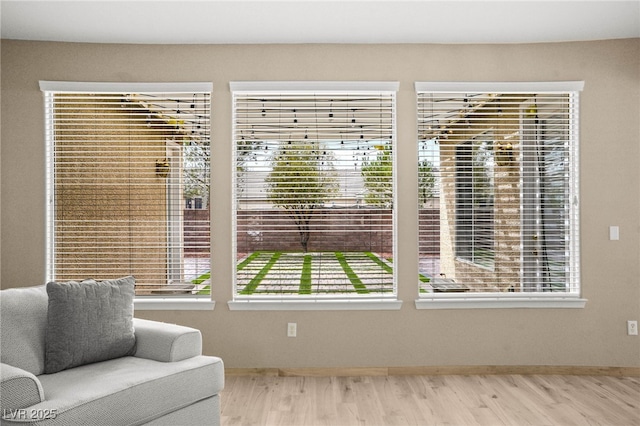 sitting room with baseboards and wood finished floors