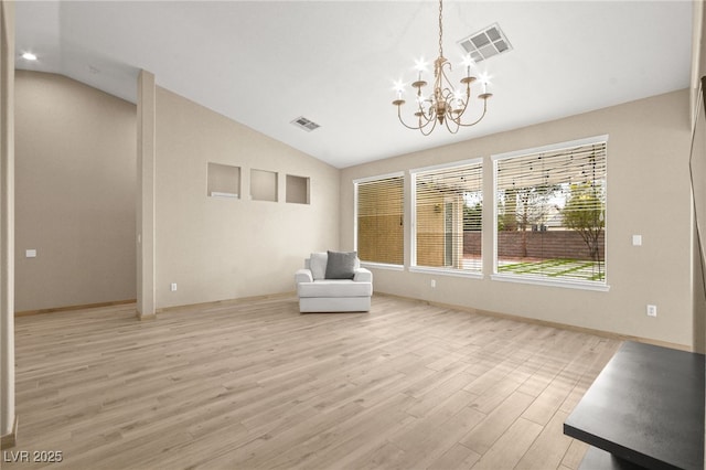 unfurnished room with vaulted ceiling, a notable chandelier, light wood-style floors, and visible vents