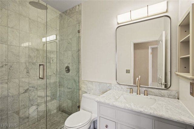 full bathroom with vanity, a shower stall, and toilet