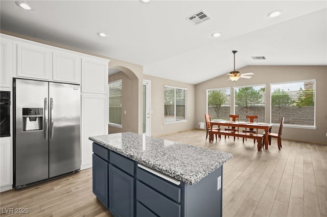 kitchen with visible vents, arched walkways, white cabinets, stainless steel fridge with ice dispenser, and light wood finished floors